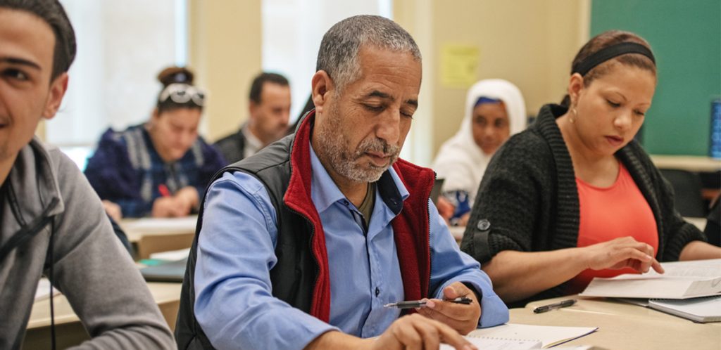 A classroom of adult learners studying from books