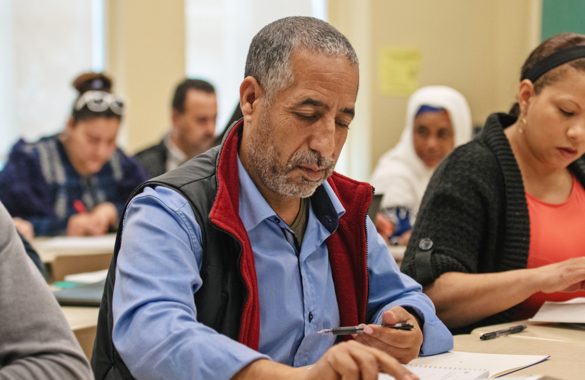 A classroom of adult learners studying from books