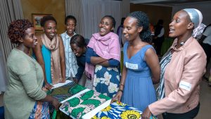 A participant who sells fabrics discusses her business model with fellow participants at a Re:BUiLD business fair in October 2024.